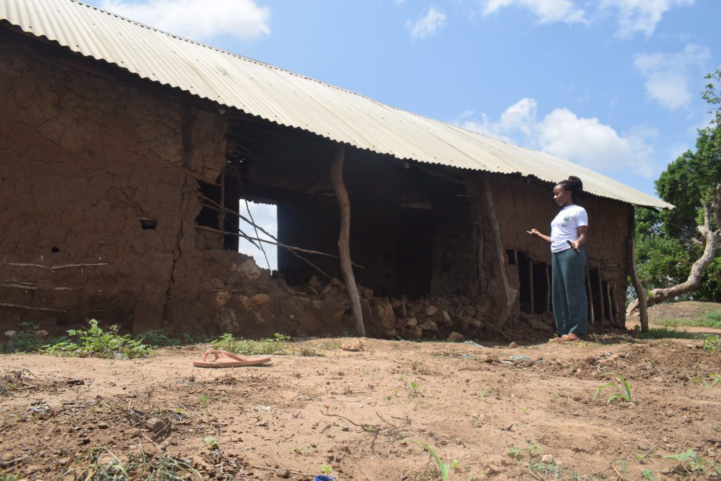 Haki Yetu Org Officer Warda Nzighe inspects a damaged house by a mob who killed Kesi Kenga Salehe in December 2021 in Kavunyalalo Village, Malindi Sub-County in Kilifi County over witchcraft claims. / Photo Courtesy of Haki Yetu Org.